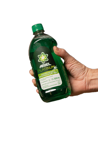 Una mano sostiene una botella de 800 ml color verde de jabón líquido para la ropa Ariel Platinum máxima limpieza quitamanchas